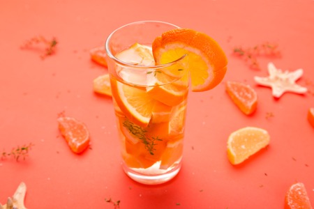 Orange fruit cocktail, detox water on orange background. Summer timeの写真素材