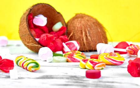 Explosion of candies from coconut on yellow paper background. Copy space. の写真素材