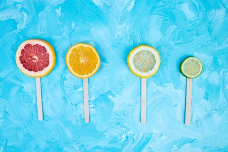Citrus slice icepop on a blue background. Flat lay.