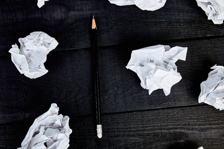 Concept in search ideas. Creased paper of idea and pencil on balck wooden background.. Still life, business concept. Flat lay. Top view.の写真素材