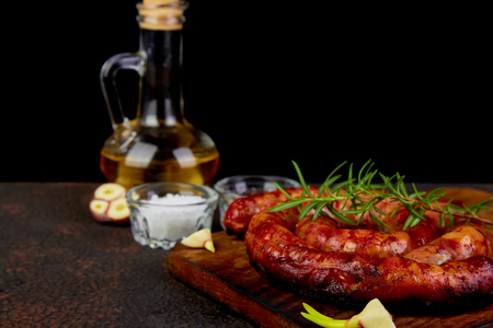 Grilled  or Roasted spiral pork sausages with rosemary, salt and peper on wooden cutting board.
の写真素材