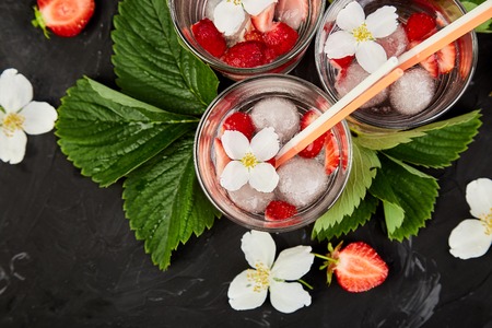 Strawberry detox water with jasmine flower. Summer iced drink or tea. Lemonade with berry. Flavored Water in glasses with Fresh Strawberry. Copy Space. Diet. Top Viewの写真素材