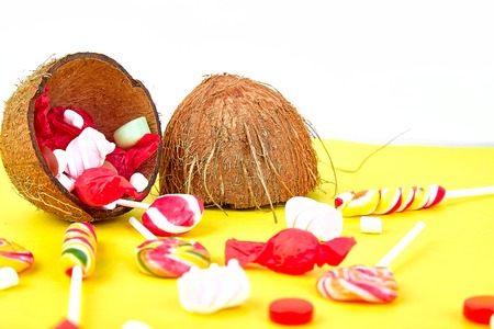 Explosion of candies from coconut on yellow paper background. Copy space.の写真素材