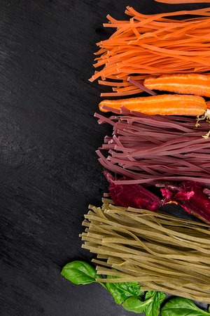 Colored Raw Vegetable Vegetarian Pasta with Beets, Carrots and Spinach. Flat lay. Copy space. Top view. Frame.の写真素材