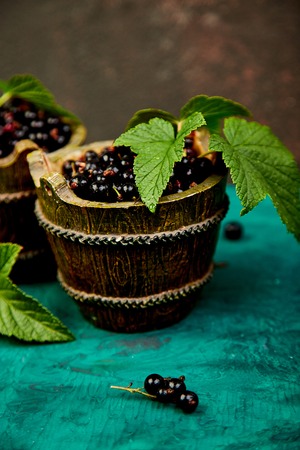 Blackcurrant berries with leaves, black currant in green bowls. Copy space.の写真素材