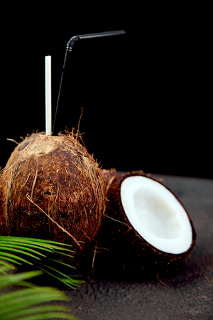 Coconut cocktail on brown background. Summer holiday drink concept, tropical cocktails or juices in coconut. Copy space.の写真素材
