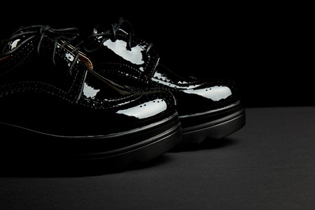 Woman female black oxford platform shoes on black background. Brogue shoes. Copy space.の写真素材