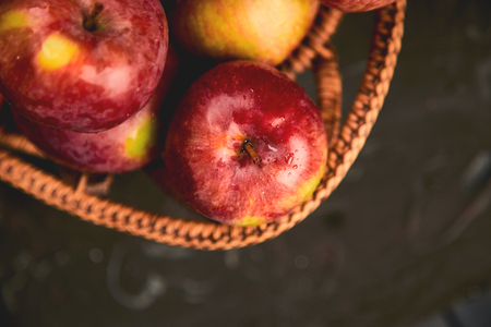 Fresh organic red apples in a basket on a black background. Autumn harvest.  Flat lay. Top view. Copy space.の写真素材