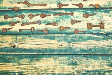 Collection of many different old retro keys in order on wooden rustic background concept. Creative...