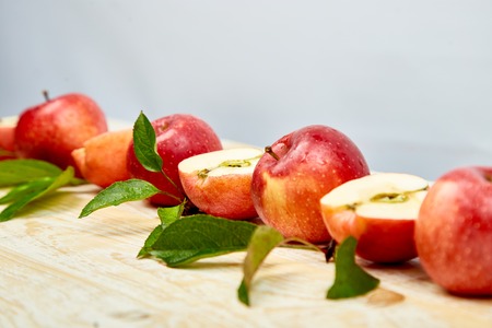 Fresh red ripe apples fruits whole and sliced on light wooden rustic