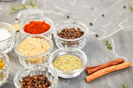 Seasoning background. Spice and herb seasoning with fresh and dried herbs and spices in bowls. Colourful various herbs and spices for cooking on grey background.の写真素材