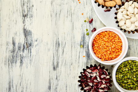Bowls of various legumes red turkish lentils, chickpeas, beans, peanuts, peas, canadian lentils on white background. Collection set of beans and legumes. Top view. Copy space.の写真素材
