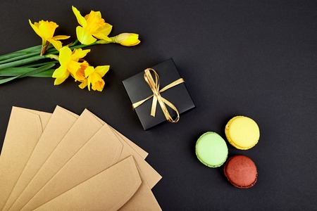 Bouquet flowers narcissus gift and sweets or cake macarons. Good morning. Woman or mother...