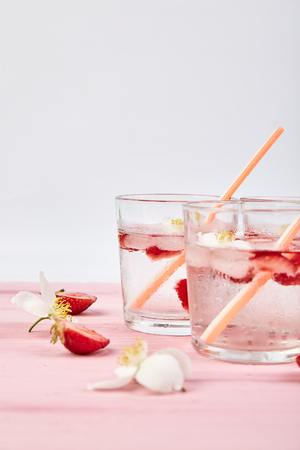 Strawberry detox water with jasmine flower. Summer iced drink or tea. Lemonade with berry. Flavored Water in glasses with Fresh Strawberry. Diet.の写真素材