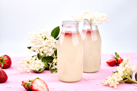 Kombucha tea with elderflower and strawberry on pink background. Homemade fermented infused drink. Summer Healthy natural probiotic flavored drink. Copy spaceの写真素材