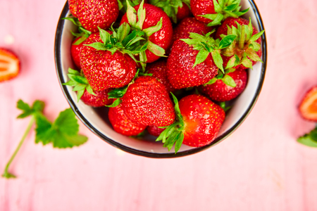 Ripe red strawberries on pink table, Strawberries in bowl. Fresh strawberries. Beautiful strawberries. Diet food. Healthy, vegan. Top view. Flat lay.の写真素材