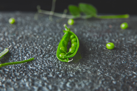 Flat lay composition with delicious fresh green peas on black background. Vegan and vegetarian food concept. の写真素材