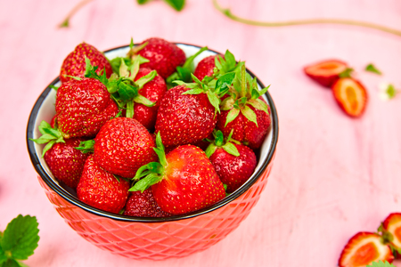 Ripe red strawberries on pink table, Strawberries in bowl. Fresh strawberries. Beautiful strawberries. Diet food. Healthy, vegan. Close up.の写真素材