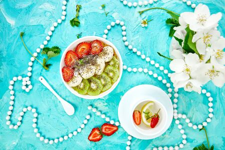 Healthy breakfast bowl smoothie with strawberry, banana, kiwi  and chia seeds on blue background. Healthy vegan food concept.
の写真素材