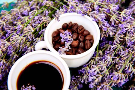 Coffee, coffee grain in cups and lavender flower on green background from above. Good Morning concept. Woman working desk. Cozy breakfast. Mockup. Flat lay styleの写真素材