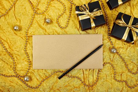 Pile of handmade luxury black gift boxes with gold ribbon DIY decoration, blank sheet paper for greeting text,  gold wedding invitation. Birthday, christmas holiday concept. Copy space. Top view. Flat design. Flat lay.の写真素材