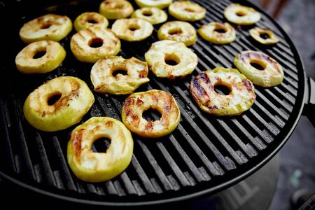 Grilled apples on black gas grill. Grilled dessert. Barbecue fruit. Copy space. Healthy food. Vegan food.の写真素材