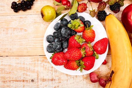 Flat lay of fruits over white wooden background, top view. Vegetarian, vegan, dieting, clean eating, weight loss ingredients. Summer fruit food background. Copy space.の写真素材
