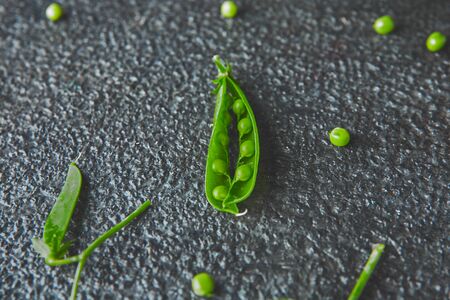 Flat lay composition with delicious fresh green peas on black background. Vegan and vegetarian food concept.の写真素材