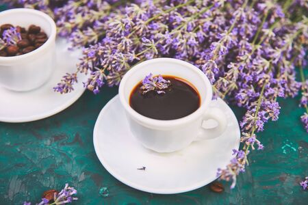 Coffee, coffee grain in cups and lavender flower on green background from above. Good Morning concept. Woman working desk. Cozy breakfast. Mockup. Flat lay styleの写真素材