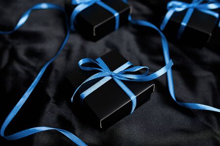 Luxury black gift boxes with blue ribbon on shine black background. Christmas, birthday party presents. Father Day. Flat lay. Copy space. Top view.の写真素材