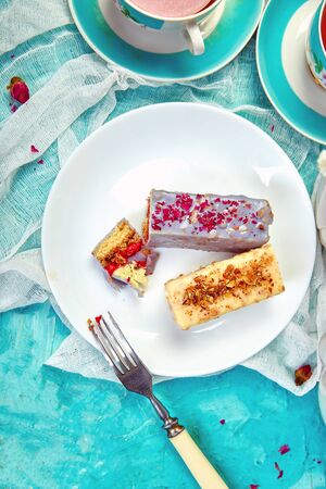 Mini Mousse Cake with chocolate, covered with blue spray and decorated with pink roses with cups of...
