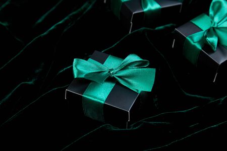 Luxury black gift boxes with green ribbon on shine velvet background. Christmas, birthday party presents. Father Day. Flat lay. Copy space. Top view.の写真素材