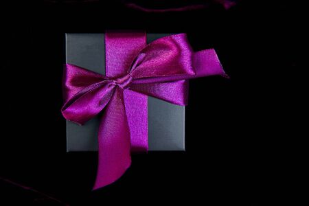 One luxury black gift boxe with green ribbon on shine velvet background. Christmas, birthday party presents. Father Day. Flat lay. Copy space. Top view.の写真素材