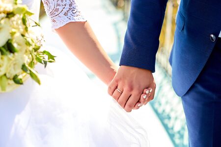 Wedding bouquet. The girl in a white dress and a guy in a suit sitting are holding a beautiful...