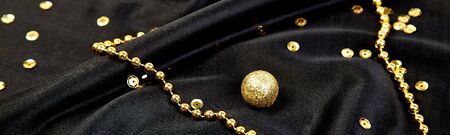 Banner with Luxury black background with gold shiny balls. Christmas, birthday party. Flat lay. Copy...