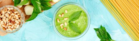 Banner of Italian food. Homemade pesto sauce in glass jar with ingredients.