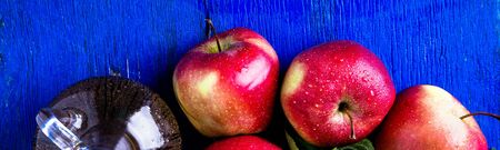 Banner of Apple cider vinegar. One glass bottle on blue background. Red apples. Top viewの写真素材