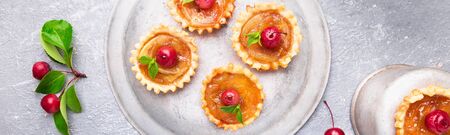 Banner of Apple caramel little tarts on grey background. French tatin with paradise apple. Top view