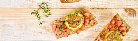 Banner of Appetizer bruschetta with tuna and tomatoes on wooden background. Italian cuisine....