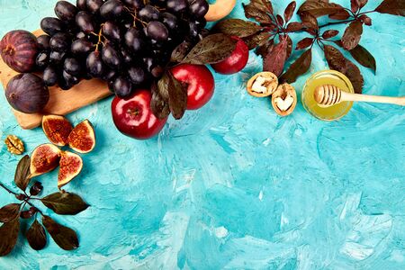 Autumn frame background. Autumn food still life with season fruits grape, red apples and figs on a blue table. Thanksgiving dayの写真素材