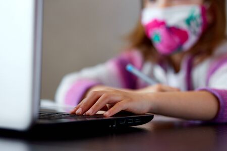 Unrecognizable girl, Schoolgirl studying at home with a notebook and doing school homework. Distance learning online education. Coronavirus home school concept, quarantine.の写真素材