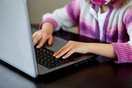 Unrecognizable girl, Schoolgirl studying at home with a notebook and doing school homework. Distance learning online education. Coronavirus home school concept, quarantine.の写真素材