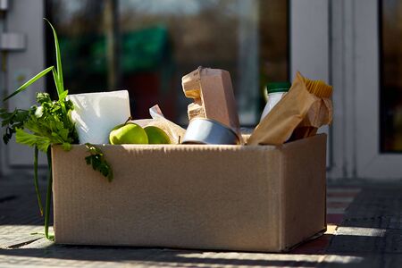 Delivery during the quarantine. Box with Merchandise, goods and food at door of homeの写真素材