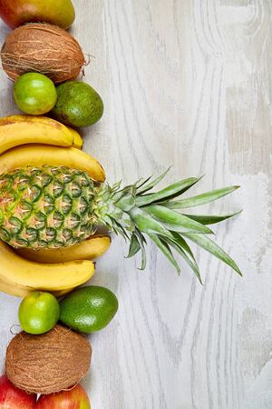 Flat lay of exotic fruits on white background - mango, pineapple, banana, avocado, coconut, lime. Top view. Creative layout made of tropical fruits, copy space, summer concept.の写真素材