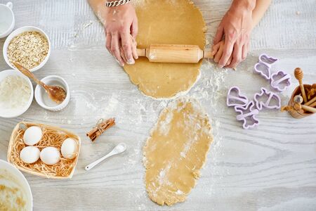 Top view of Father and  his little daughter hands roll dough for cookies, baking in kitchen, family...