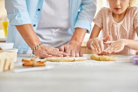 Father and daughter preparing dough together in kitchen, Family cooking at home, fatherhood and family weekend concept.の写真素材