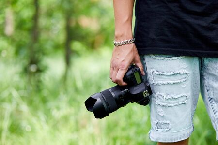 Man photographer with a photo camera in hand outdoor, World photographer day, creative hobby, copy space, place for text, Photography Concepts Professional.の写真素材