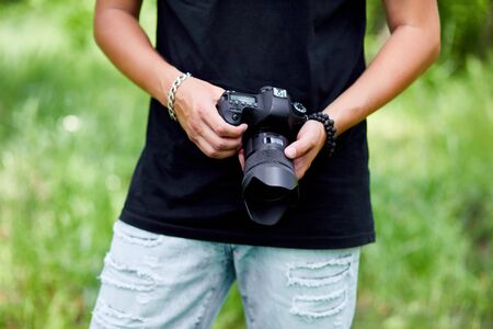 Man photographer with a photo camera in hand outdoor, World photographer day, creative hobby, copy space, place for text, Photography Concepts Professional.の写真素材