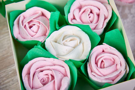 Gift box with homemade pastel multi color marshmallows. Apple zephyr in the shape of flowers roses. Beautiful delicious fruit dessert on white wooden table.の写真素材