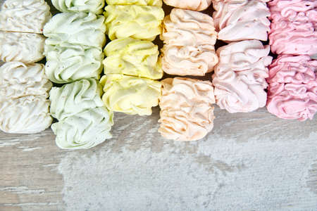 Sweet homemade marshmallow, background from multicolor pastel zephyr, top view, copy space. Flat...